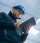 Factory worker in a hard hat is using a tablet computer.